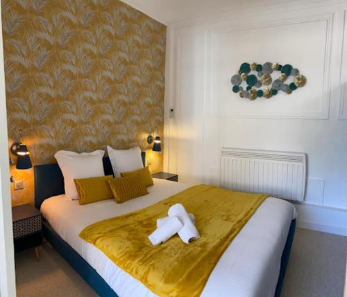 Cette chambre comprend un lit avec une croix. dans l'établissement Appartement élégant au cœur de Cabourg, à Cabourg