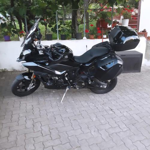 a black motorcycle parked on a brick street at AceroRosso B&B in Salerno
