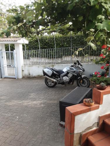 a motorcycle parked in a parking lot next to a fence at AceroRosso B&B in Salerno