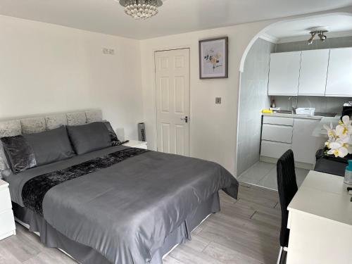 a bedroom with a bed and a small kitchen at Outhouse fully equipped studio in London