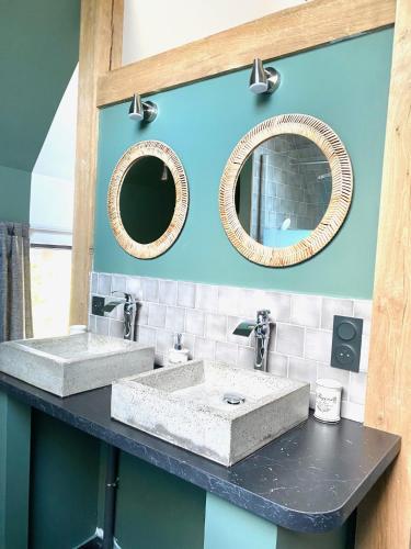 une salle de bain avec deux lavabos et deux miroirs dans l'établissement La Grange du Tillieul - Haras de la varende, à Le Mesnil-Simon