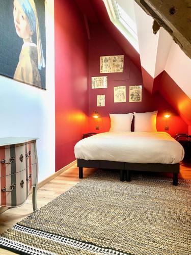 - une chambre avec un lit aux murs rouges dans l'établissement La Grange du Tillieul - Haras de la varende, à Le Mesnil-Simon