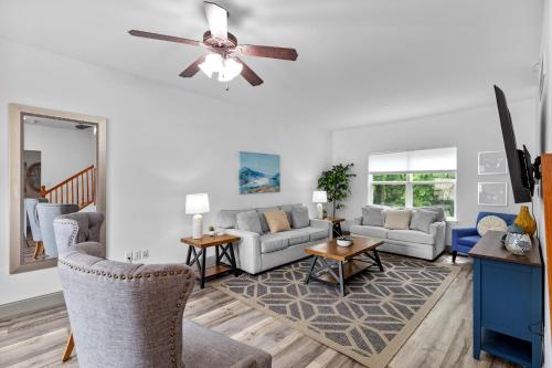 a living room with couches and a ceiling fan at Springhurst Serenity Fresh 4BR Getaway in O'Fallon