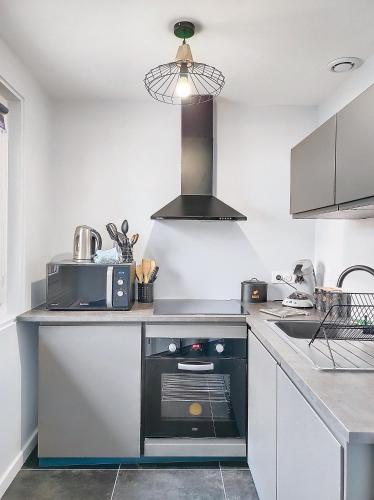 a kitchen with a sink and a stove in it at L'atelier d'Anatole in Oyonnax