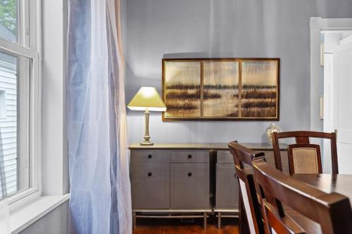 a dining room with a table with a lamp and a window at Historic 2 bedroom house St Charles in St. Charles