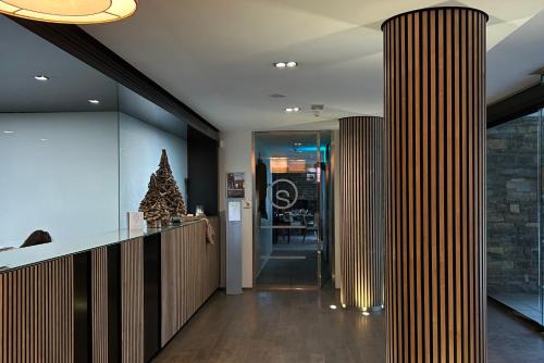 a lobby with columns and a christmas tree at Aparthotel Siente Boí & SPA in Pla de l'Ermita