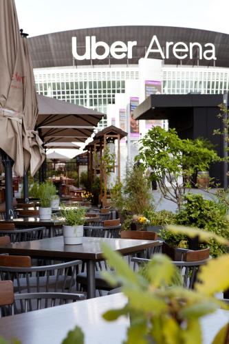 a restaurant with tables and umbrellas in front of a building at Hotel Indigo Berlin - East Side Gallery in Berlin