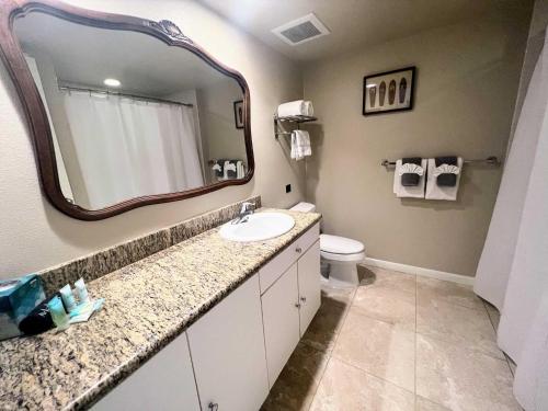 a bathroom with a sink and a mirror and a toilet at Islander on the Beach 351 in Kapaa