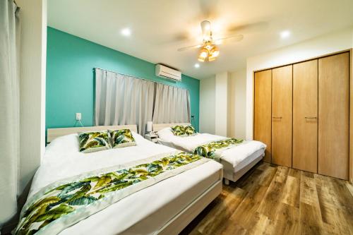 two beds in a bedroom with blue walls and wooden floors at 63, Shiomi, First floor of the apartment, 潮見1F in Tokyo