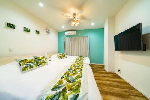 a bedroom with two beds and a flat screen tv at 63, Shiomi, First floor of the apartment, 潮見1F in Tokyo
