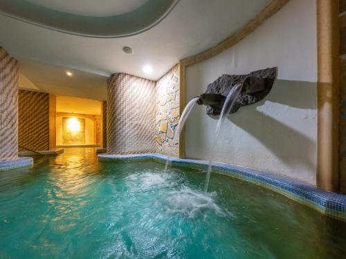 a pool with a water fountain in a hotel room at Av Isola Verde Hotel Thermal Spa in Ischia
