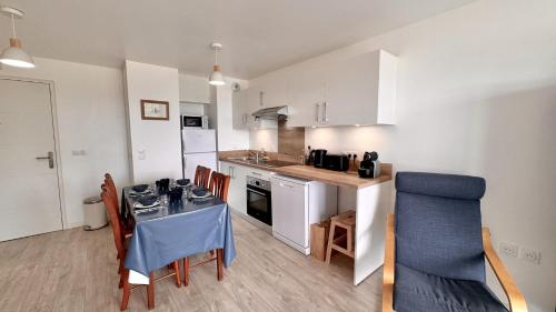 une cuisine avec une table et des chaises dans une pièce dans l'établissement Le 110 appartement, à Saint-Valery-sur-Somme