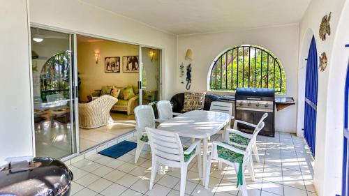 a kitchen and living room with a table and chairs at Santorini - 8 Pyrgos in Ballito