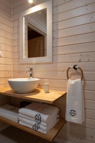 a bathroom with a sink and a mirror and towels at Off White Domki Darłówko in Darlowko