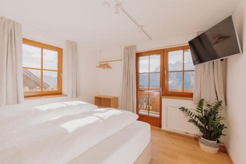 a white bedroom with a large bed and a window at VOM REITER, Ferienwohnung am Bauernhof mit Bergblick und privater Infrarotkabine, Inklusive Sommercard in Schladming