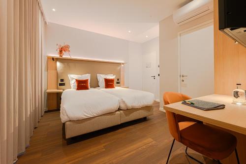 a hotel room with a bed and a desk with a desk at The CORNR Hotel in Nieuwpoort
