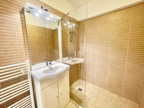 une salle de bain avec un lavabo, un miroir et une douche dans l'établissement Branly by Welcome to Cannes, à Cannes