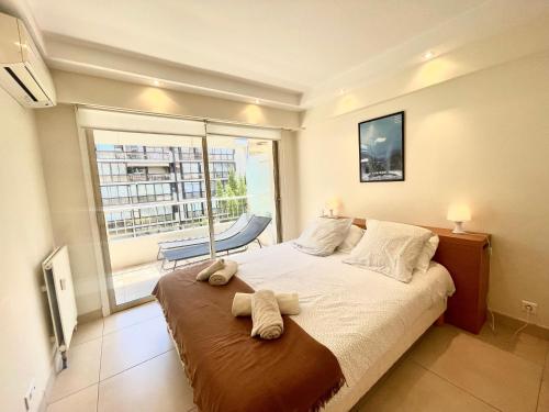 une chambre avec un grand lit et une grande fenêtre dans l'établissement Branly by Welcome to Cannes, à Cannes
