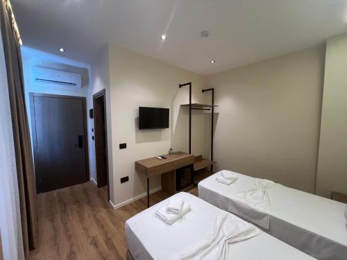 a room with two beds and a sink and a mirror at Andi Downtown Deluxe Rooms in Vlorë