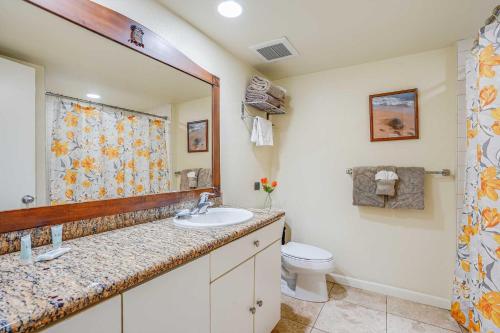 a bathroom with a sink and a toilet and a mirror at Islander on the Beach 115 in Kapaa