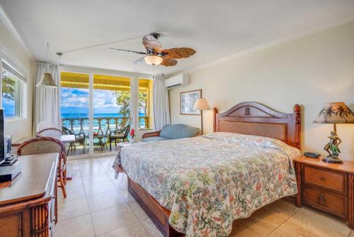 een slaapkamer met een bed, een bureau en een raam bij Islander on the Beach 323 in Kapaa