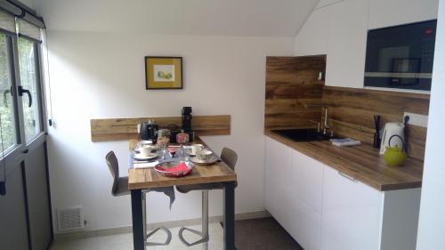 a small kitchen with a table and a sink at L'Atelier in Bayeux