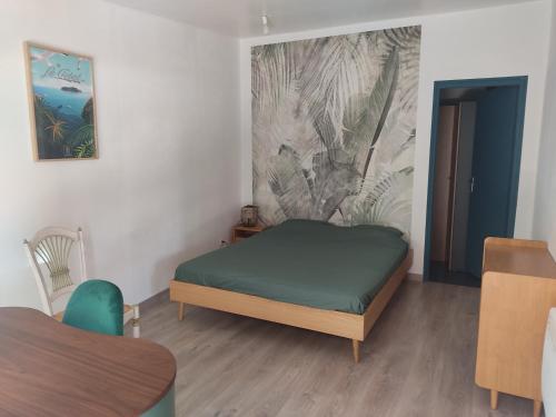 une chambre avec un lit, une table et des chaises dans l'établissement la ciotat belle maison centre ville avec parking, à La Ciotat