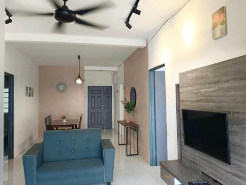 a living room with a blue couch and a flat screen tv at Irdina HomestayMuslim's at Emerald Avenue Brinchang Centrum in Brinchang