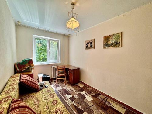 a bedroom with a bed and a desk and a window at 4rent Two bright bedrooms apartment in Chişinău