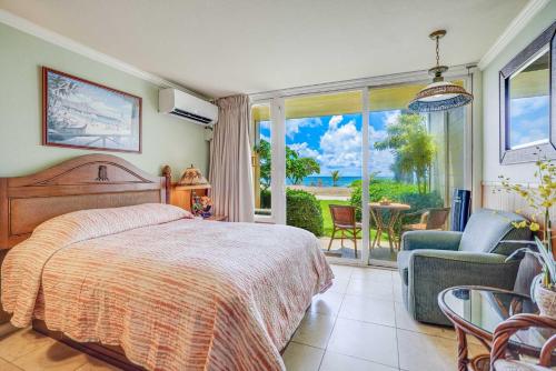 a bedroom with a bed and a view of a patio at Islander on the Beach 152 in Kapaa