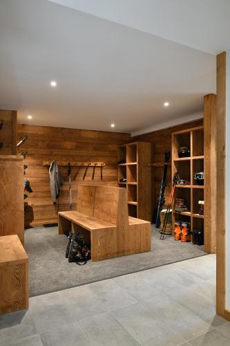 Cette chambre dispose de murs en bois, d'une table et d'étagères. dans l'établissement Valmarélie, à Villard-Reculas