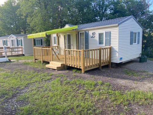 a tiny house with a porch and a deck at Camping maeva Respire de La Croze in Châtel-Guyon