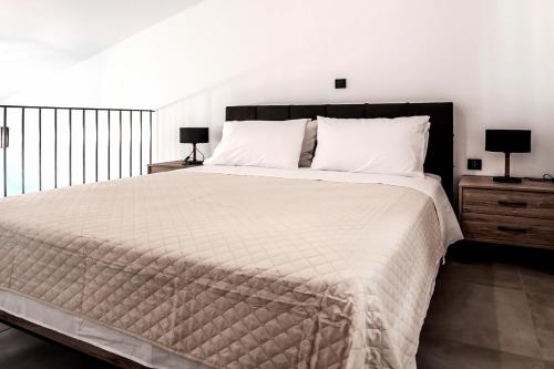 ein Schlafzimmer mit einem großen Bett mit weißen Laken und Kissen in der Unterkunft Charisma Resort in Ímeros
