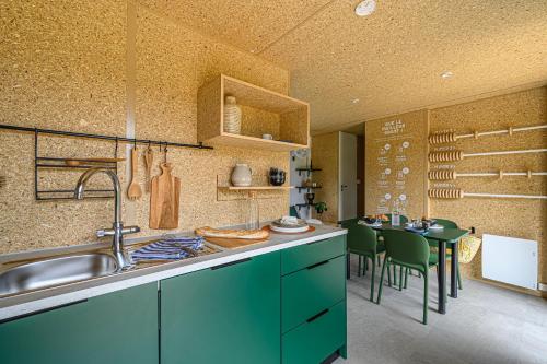 a kitchen with a sink and a table with chairs at Camping maeva Respire de La Croze in Châtel-Guyon