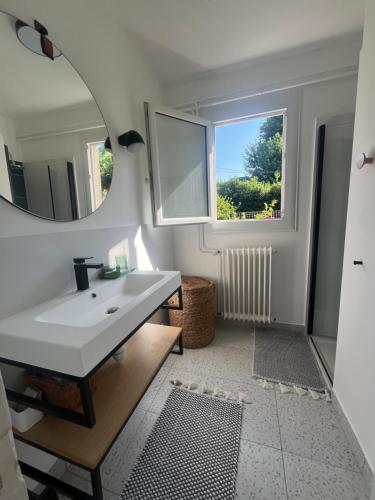 a bathroom with a white sink and a mirror at Chez Gilles et Aline in Figeac