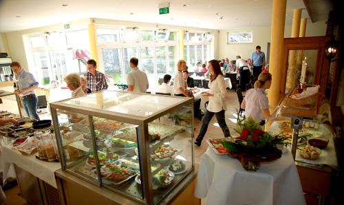 Un groupe de personnes debout dans une pièce avec de la nourriture dans l'établissement Hotel Brauhaus Stephanus, à Coesfeld