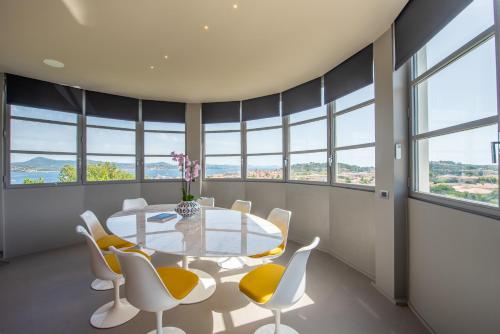 une salle à manger avec une table, des chaises et des fenêtres dans l'établissement La Rotonda - Incredible Méditerranéen and St Tropez view 360! Centre ville 5 mns, à Saint-Tropez