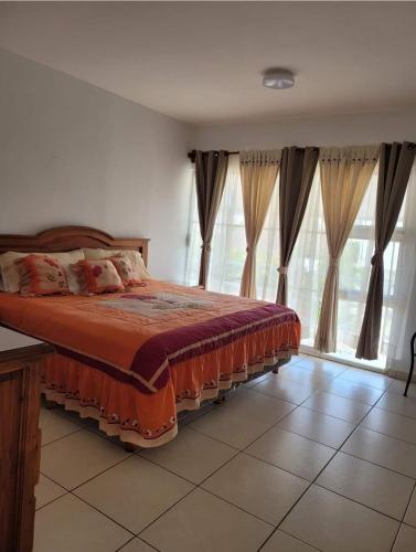 a bedroom with a bed in a room with windows at Nuevo Vallarta Casa Neptuno in Nuevo Vallarta