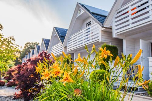 a house with flowers in front of it at Domki OLIVIA in Darlowko