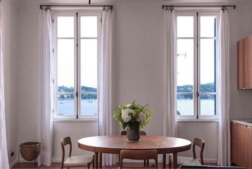 une salle à manger avec une table avec un vase de fleurs dans l'établissement Blue House, à Villefranche-sur-Mer