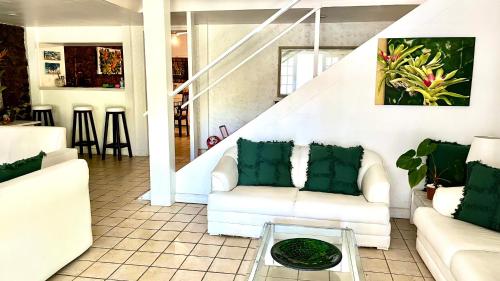 a living room with white couches and a glass table at GUEST HOUSE Floresta Mar in Angra dos Reis