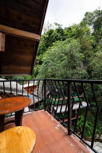 a balcony with a table and chairs on it at ไชยพล โฮมสเตย์ หมู่บ้านแม่กำปอง in Ban Pok Nai
