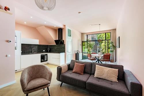 a living room with a couch and a kitchen at Stylish apartment next to the Amstel river- Unit F in Amsterdam