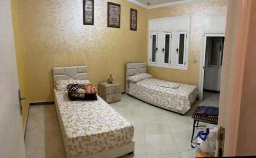 une chambre avec deux lits dans une pièce dans l'établissement اقامة علي, à Al Hoceïma