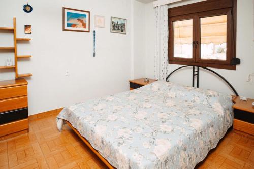 a bedroom with a bed and a window at Sylvi Maisonette Volos in Melissátika