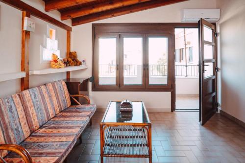 a living room with a couch and a table at Sylvi Maisonette Volos in Melissátika