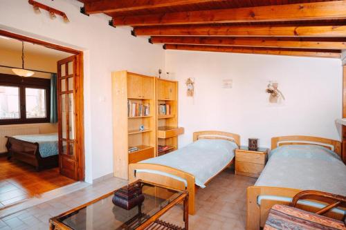 a bedroom with two beds and a table at Sylvi Maisonette Volos in Melissátika