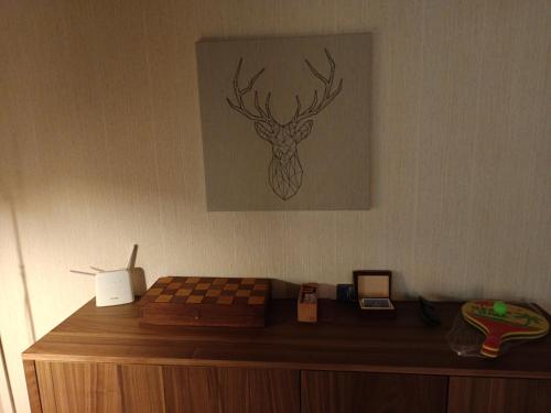 a picture of a deer on the wall above a chessboard at Le Paradis Blanc Sauna & Spa in Kortetniemi