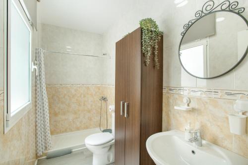 a bathroom with a sink and a toilet and a mirror at El Rincón de Mónica in Agaete