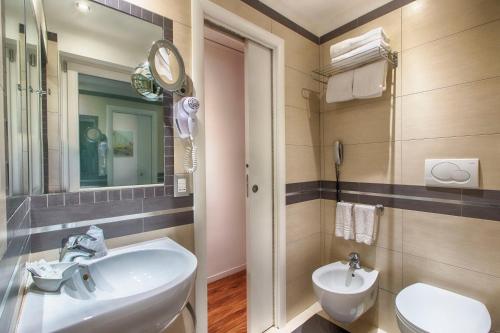 a bathroom with a sink and a toilet and a mirror at Hotel Raganelli in Rome